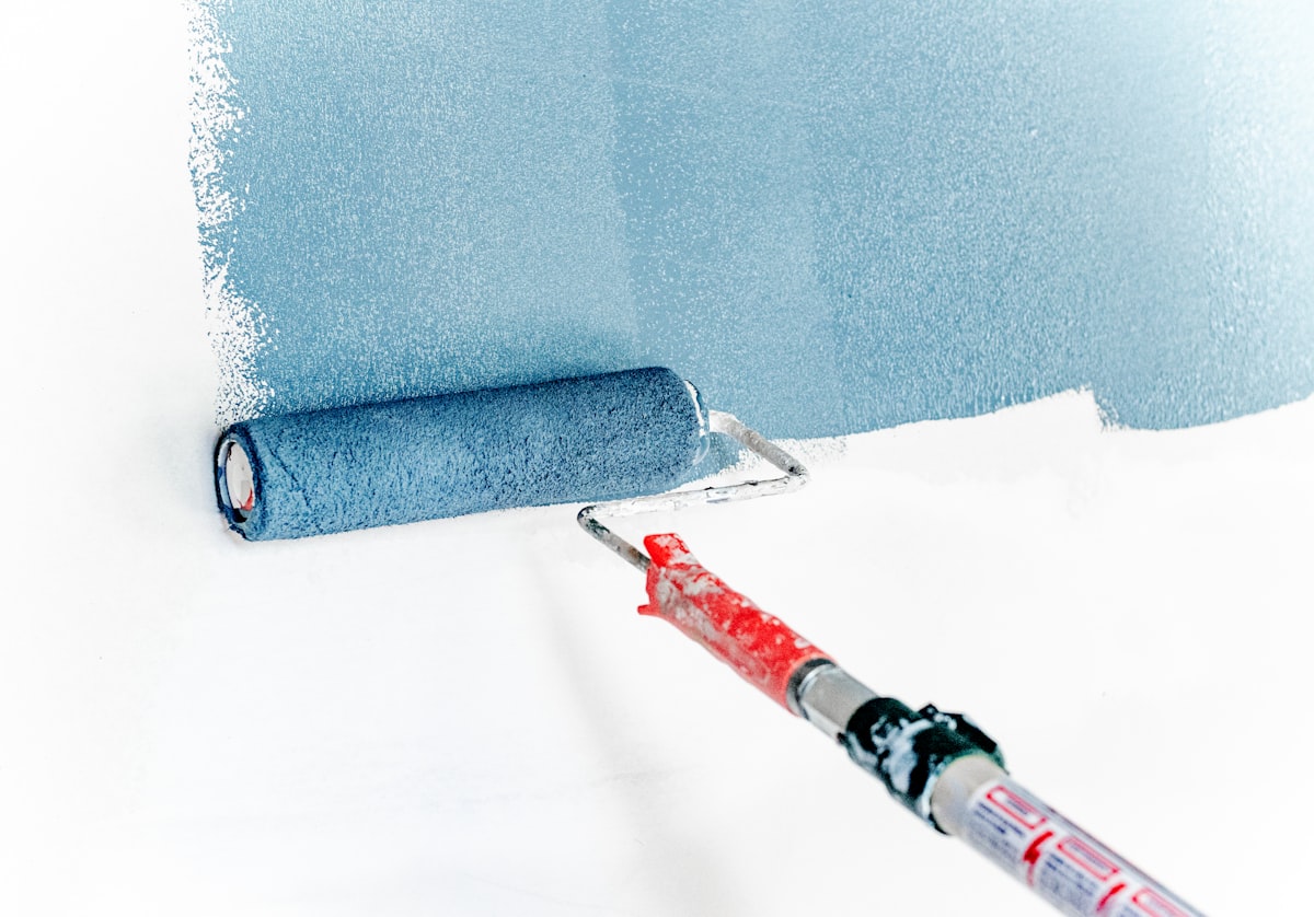 Painter rolling fresh paint onto an interior wall